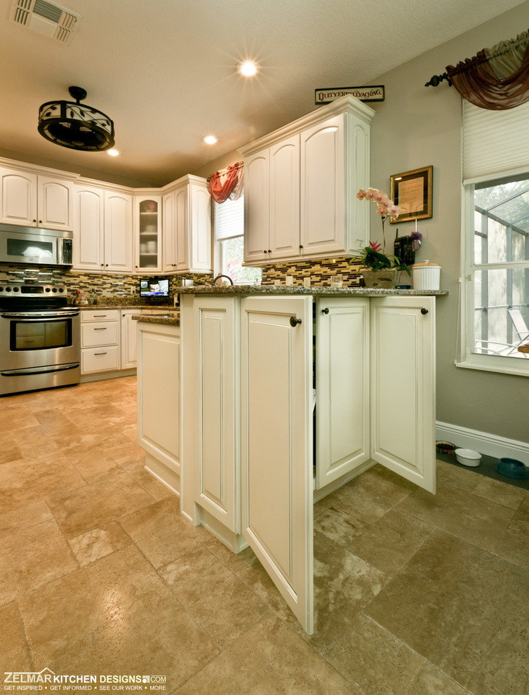 Inspiration for a mid-sized timeless u-shaped travertine floor eat-in kitchen remodel in Orlando with raised-panel cabinets, white cabinets, quartz countertops, multicolored backsplash, glass sheet backsplash and a peninsula