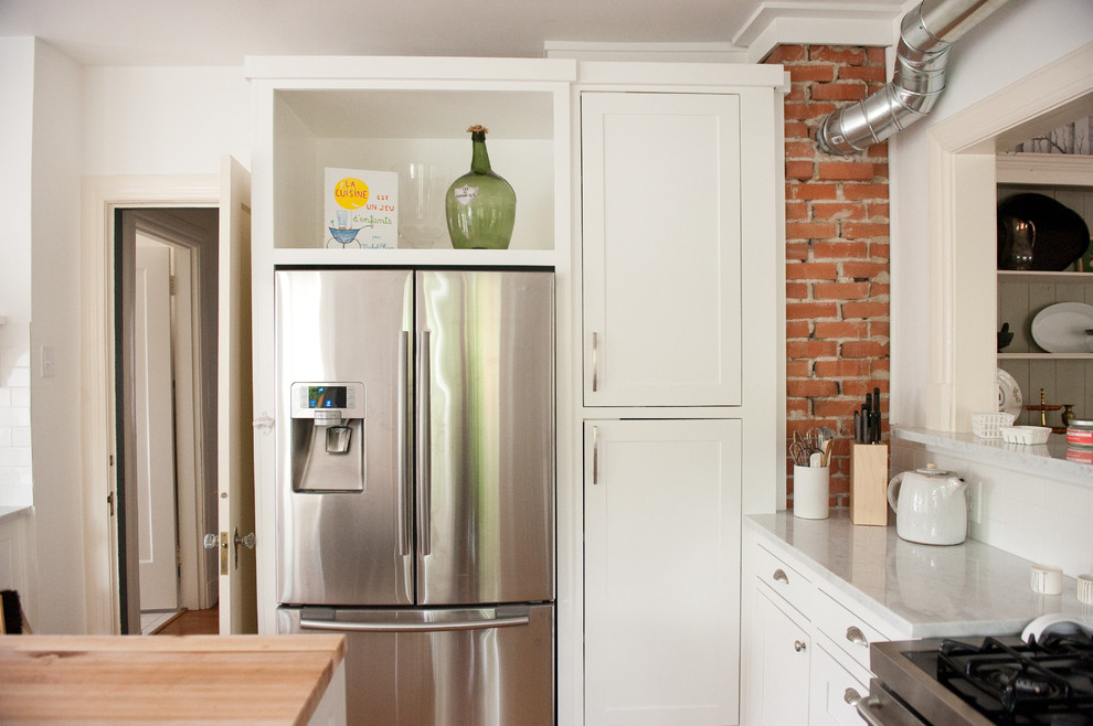 Immagine di una cucina moderna con ante in stile shaker, ante bianche e elettrodomestici in acciaio inossidabile