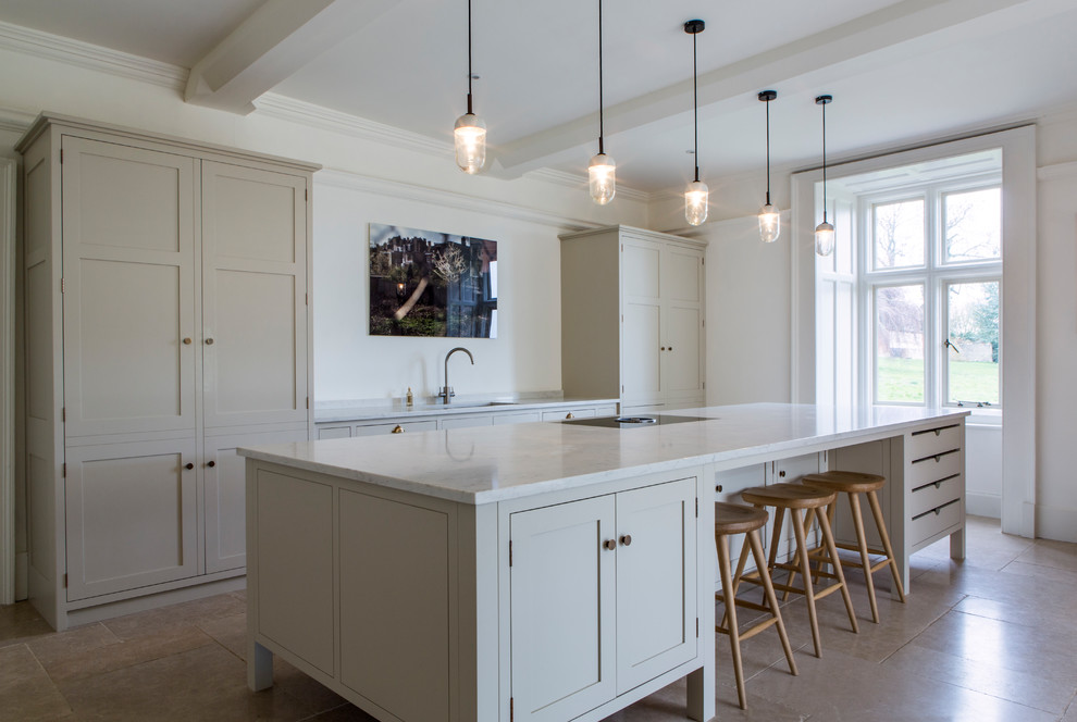 Large classic single-wall kitchen in Gloucestershire with shaker cabinets, quartz worktops, an island, a submerged sink, white cabinets, white splashback, beige floors and white worktops.