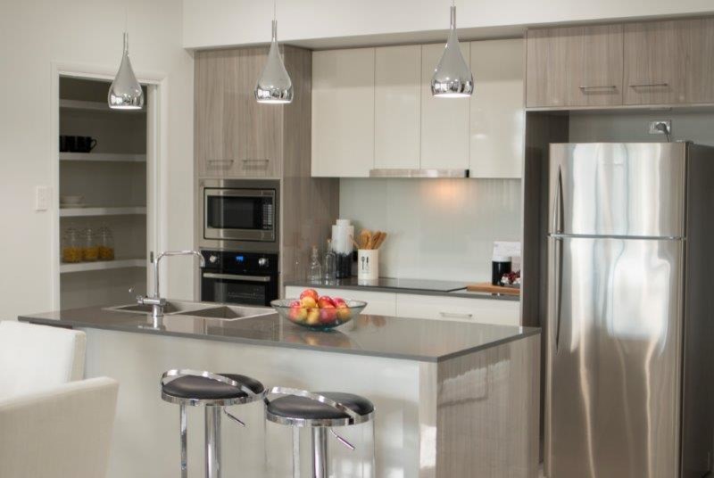 Diseño de cocina comedor contemporánea con fregadero encastrado, salpicadero blanco, electrodomésticos de acero inoxidable y una isla
