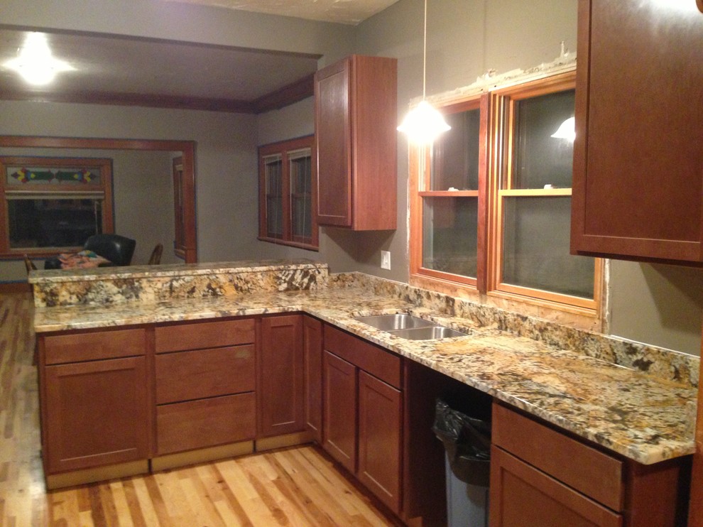 Example of a mid-sized trendy ceramic tile eat-in kitchen design in Minneapolis with a drop-in sink, raised-panel cabinets, light wood cabinets, granite countertops, stainless steel appliances and an island
