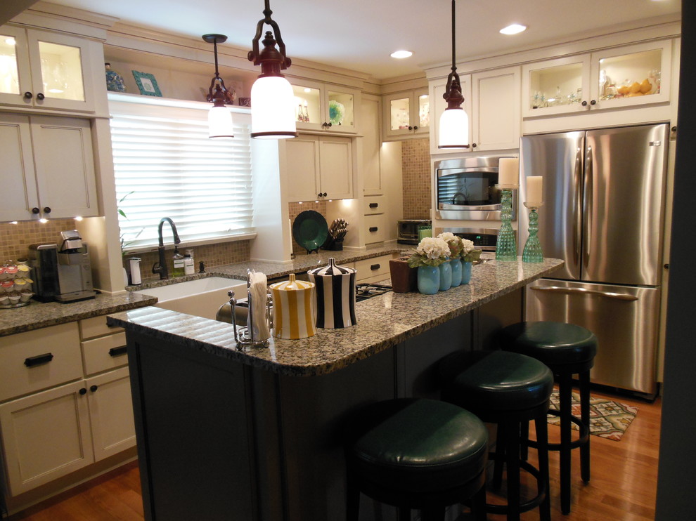 Example of an eclectic l-shaped eat-in kitchen design in Other with a farmhouse sink, recessed-panel cabinets, distressed cabinets, granite countertops, beige backsplash and stainless steel appliances