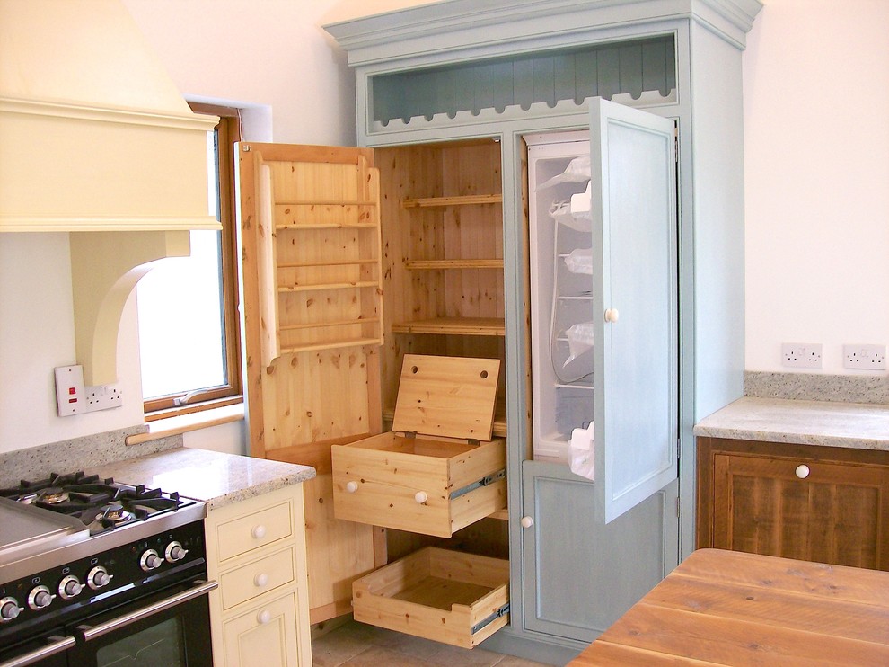 Пример оригинального дизайна: кухня в классическом стиле с кладовкой, синими фасадами и паркетным полом среднего тона