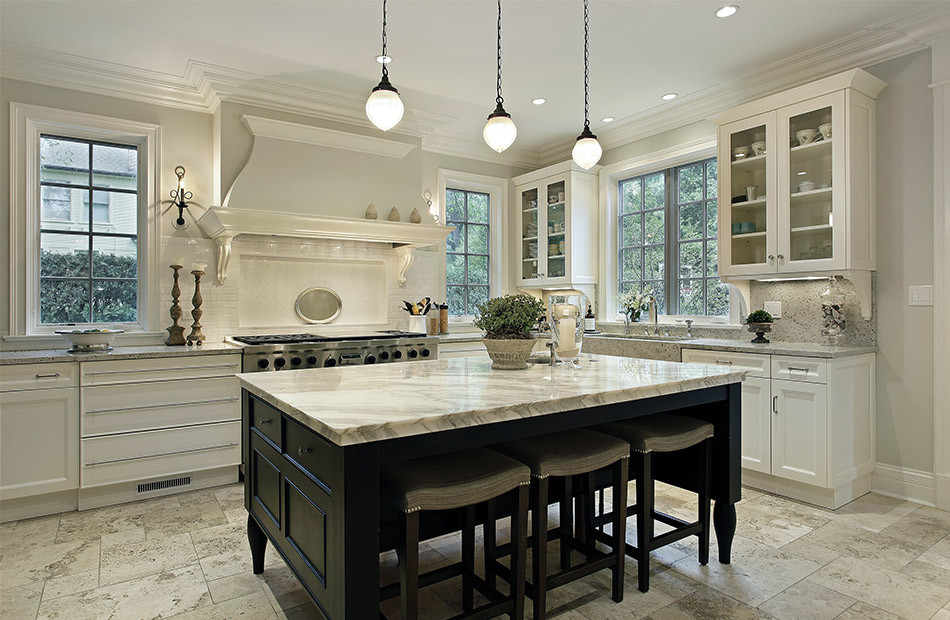 Large elegant u-shaped limestone floor enclosed kitchen photo in Cleveland with a farmhouse sink, shaker cabinets, white cabinets, marble countertops, white backsplash, subway tile backsplash, stainless steel appliances and an island