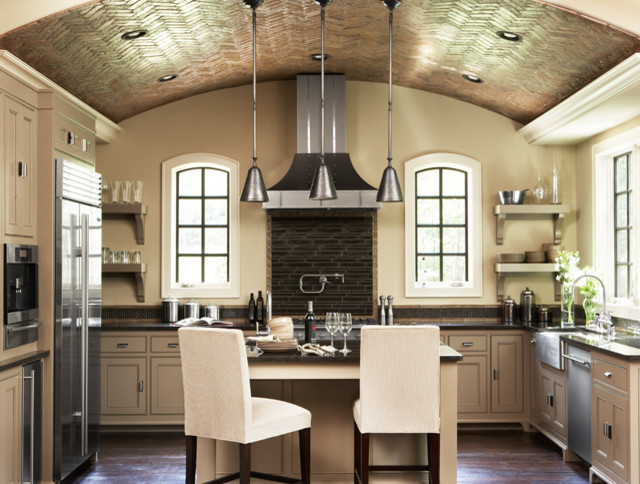 Bild på ett stort funkis kök, med en rustik diskho, skåp i shakerstil, beige skåp, granitbänkskiva, svart stänkskydd, stänkskydd i glaskakel, rostfria vitvaror, mörkt trägolv och en köksö