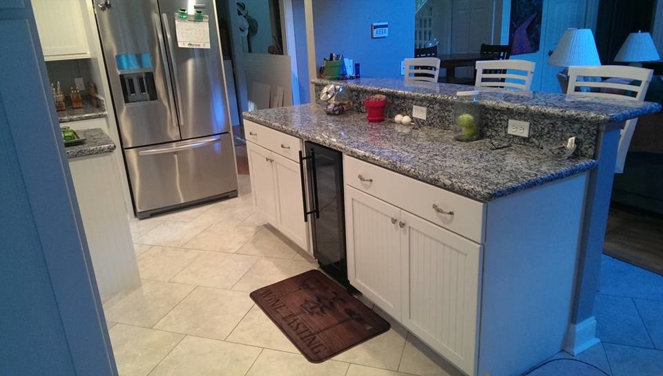 Large trendy l-shaped ceramic tile and white floor eat-in kitchen photo in San Diego with a farmhouse sink, shaker cabinets, white cabinets, granite countertops, gray backsplash, stainless steel appliances, an island and gray countertops