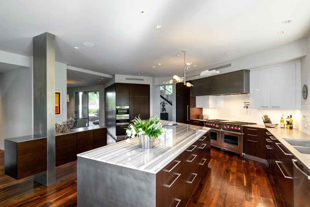 Photo of a medium sized contemporary l-shaped kitchen/diner in Phoenix with a double-bowl sink, dark wood cabinets, engineered stone countertops, white splashback, stainless steel appliances, medium hardwood flooring and an island.
