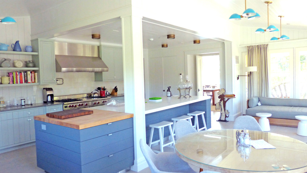 Large beach style l-shaped eat-in kitchen photo in New York with flat-panel cabinets, blue cabinets, quartz countertops, white backsplash, glass tile backsplash, stainless steel appliances and an island
