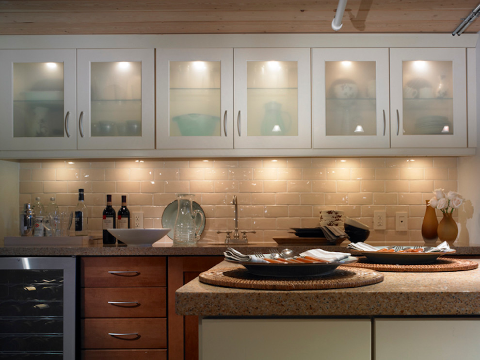 Idee per un cucina con isola centrale moderno con lavello a vasca singola, ante lisce, ante in legno chiaro, top in granito, paraspruzzi beige e paraspruzzi con piastrelle di vetro