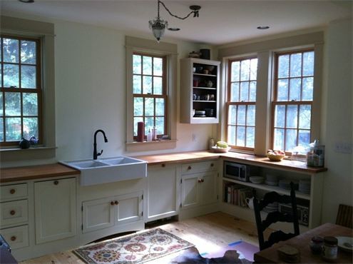 Foto på ett mellanstort lantligt kök, med en rustik diskho, luckor med profilerade fronter, vita skåp, träbänkskiva och vita vitvaror