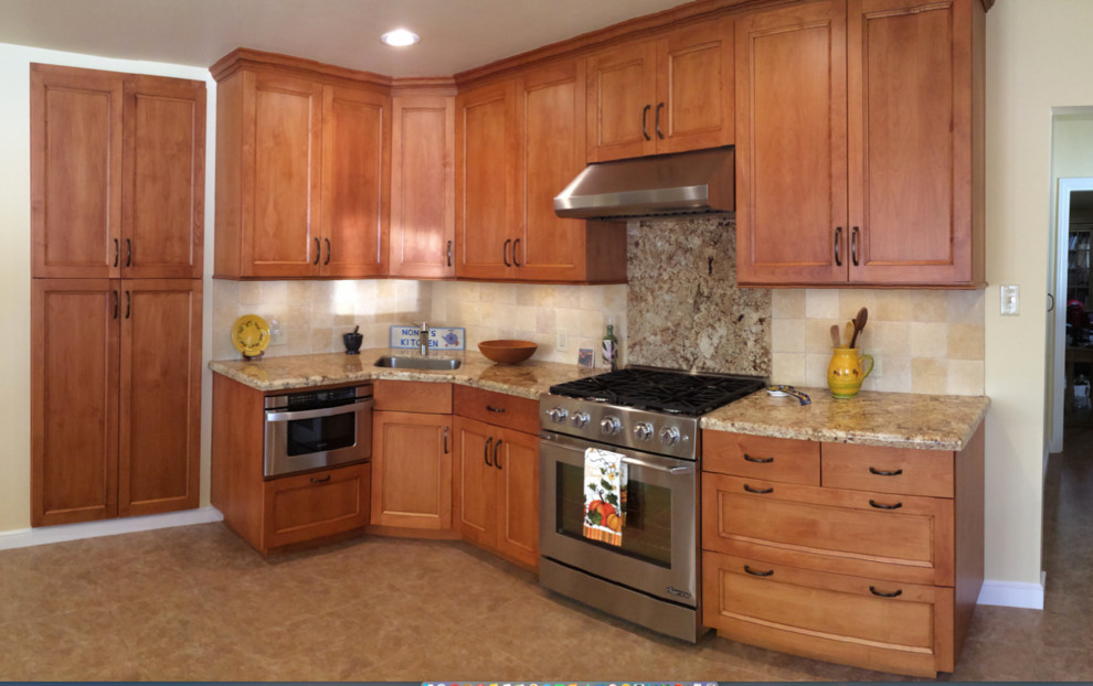 Foto på ett mellanstort vintage kök, med en undermonterad diskho, skåp i shakerstil, vita skåp, granitbänkskiva, beige stänkskydd, stänkskydd i sten, rostfria vitvaror, klinkergolv i keramik, en köksö och brunt golv