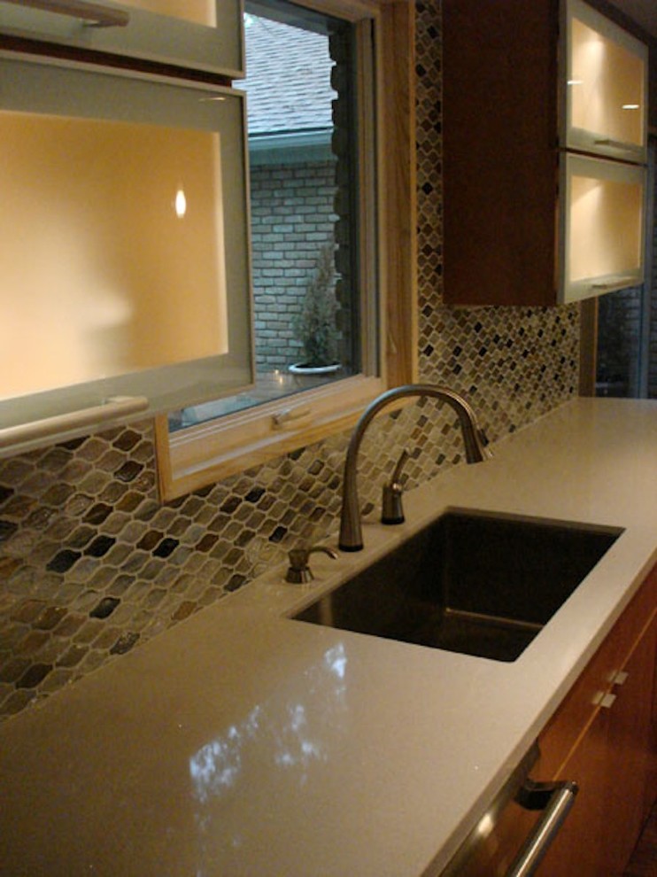 Bild på ett stort funkis kök, med en undermonterad diskho, släta luckor, skåp i ljust trä, bänkskiva i kvarts, flerfärgad stänkskydd, glaspanel som stänkskydd, rostfria vitvaror, mellanmörkt trägolv, en köksö och brunt golv