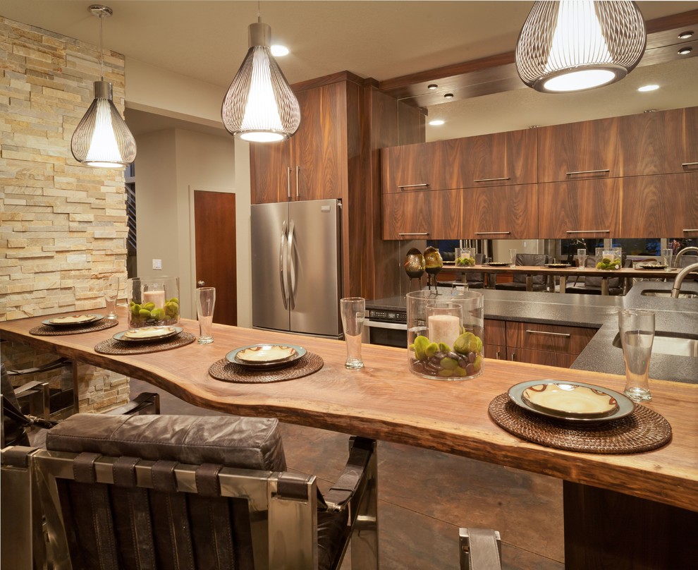 Eat-in kitchen - large contemporary u-shaped concrete floor and brown floor eat-in kitchen idea in Houston with an undermount sink, flat-panel cabinets, dark wood cabinets, wood countertops, metallic backsplash, mirror backsplash, stainless steel appliances and a peninsula