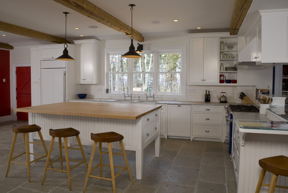 Idéer för att renovera ett mellanstort kök, med en dubbel diskho, vita skåp, bänkskiva i kalksten, vitt stänkskydd, stänkskydd i porslinskakel, rostfria vitvaror, kalkstensgolv och en köksö