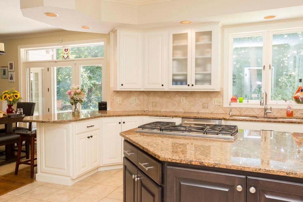 Exempel på ett stort klassiskt beige beige kök, med en trippel diskho, luckor med upphöjd panel, vita skåp, granitbänkskiva, beige stänkskydd, rostfria vitvaror, en köksö, stänkskydd i porslinskakel, klinkergolv i porslin och beiget golv