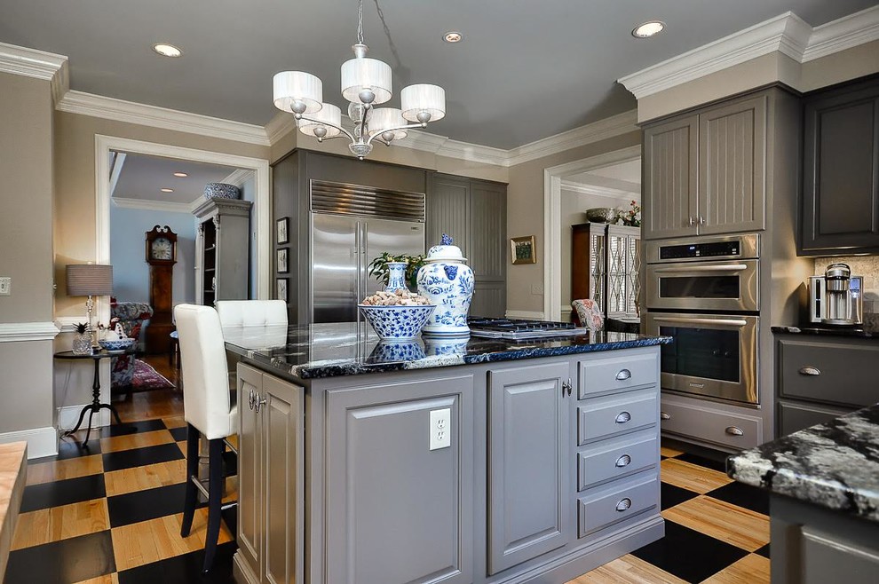 Inspiration for a mid-sized timeless l-shaped painted wood floor kitchen remodel in Other with an undermount sink, raised-panel cabinets, gray cabinets, granite countertops, gray backsplash, marble backsplash, stainless steel appliances and an island