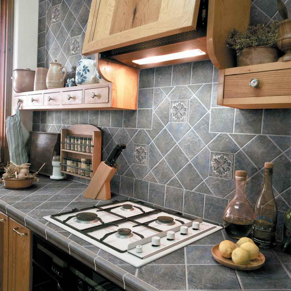 Foto di una cucina classica di medie dimensioni con ante lisce, ante marroni, top piastrellato, paraspruzzi grigio, paraspruzzi in pietra calcarea e elettrodomestici neri
