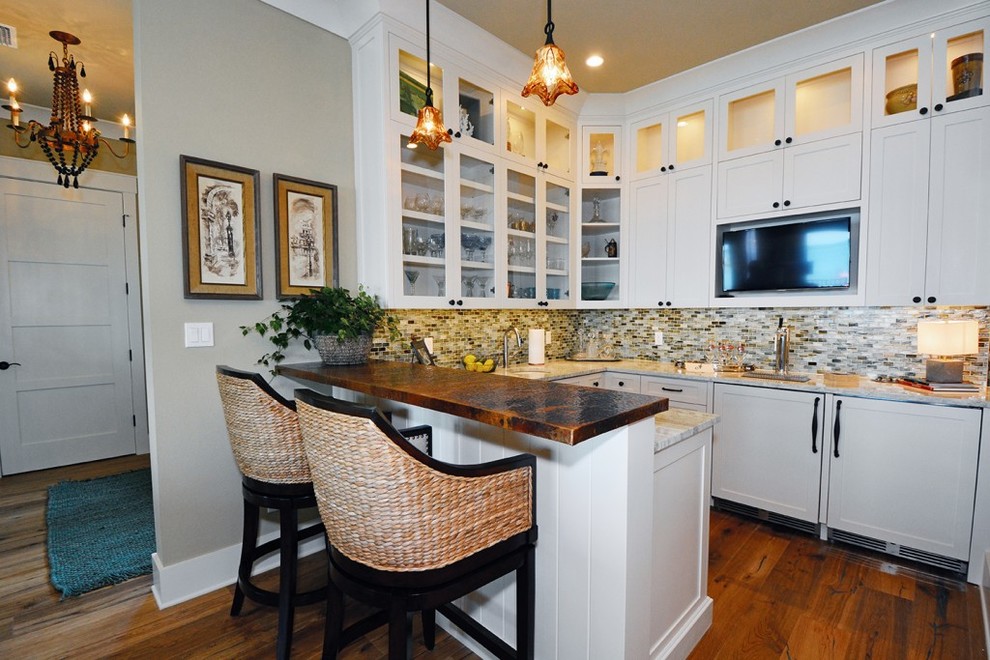 Foto på ett litet vintage kök, med skåp i shakerstil, vita skåp, bänkskiva i akrylsten, flerfärgad stänkskydd, stänkskydd i glaskakel, mellanmörkt trägolv, en undermonterad diskho, rostfria vitvaror, en halv köksö och brunt golv