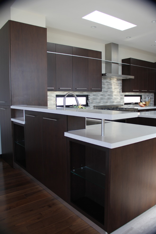 Photo of a large contemporary u-shaped open plan kitchen in Los Angeles with a submerged sink, flat-panel cabinets, dark wood cabinets, engineered stone countertops, multi-coloured splashback, matchstick tiled splashback, stainless steel appliances, medium hardwood flooring, an island and brown floors.