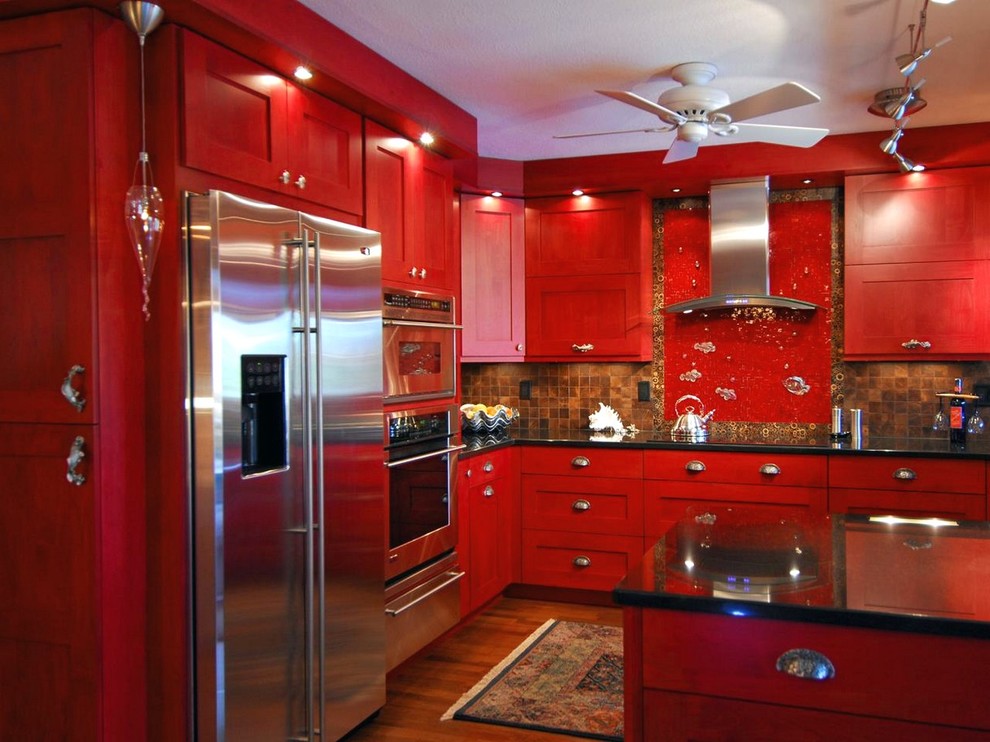 Exempel på ett avskilt, mellanstort modernt svart svart l-kök, med skåp i shakerstil, röda skåp, bänkskiva i kvarts, flerfärgad stänkskydd, stänkskydd i keramik, rostfria vitvaror, mellanmörkt trägolv, en köksö och brunt golv