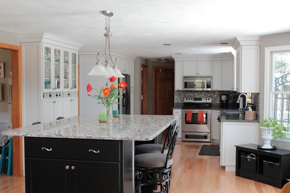 Exempel på ett mellanstort klassiskt kök, med en undermonterad diskho, luckor med upphöjd panel, vita skåp, granitbänkskiva, rostfria vitvaror och en köksö