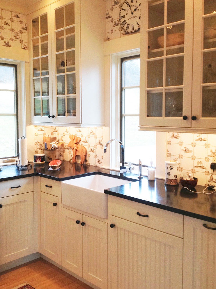 Rustikale Küche mit Landhausspüle, Glasfronten, weißen Schränken und hellem Holzboden in Burlington