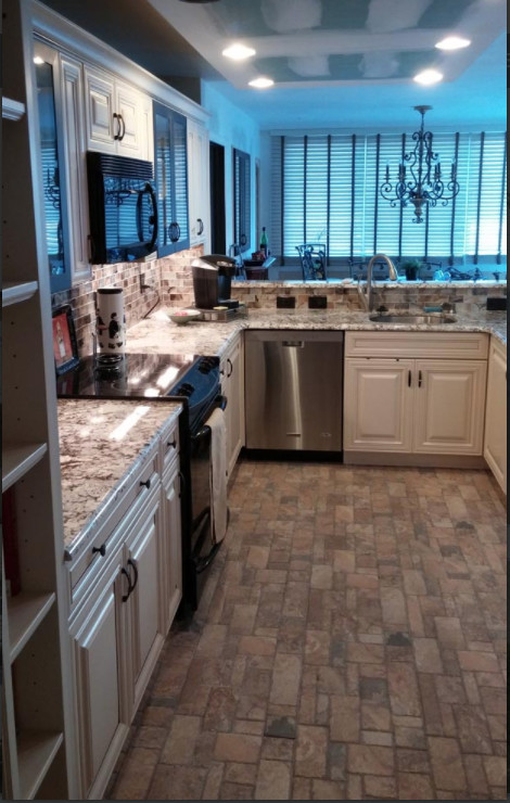 This is an example of a medium sized modern u-shaped kitchen/diner in Orange County with a submerged sink, raised-panel cabinets, white cabinets, granite worktops, mosaic tiled splashback, stainless steel appliances, slate flooring and a breakfast bar.