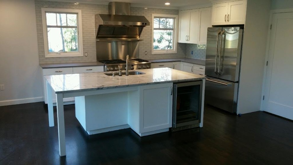 Bild på ett mellanstort funkis kök, med en undermonterad diskho, luckor med upphöjd panel, vita skåp, granitbänkskiva, stänkskydd i mosaik, rostfria vitvaror, skiffergolv och en halv köksö