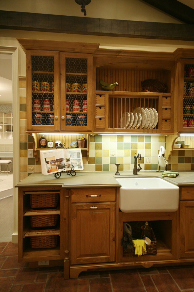 Modelo de cocina comedor clásica renovada con fregadero sobremueble, puertas de armario de madera oscura, salpicadero multicolor y suelo de ladrillo