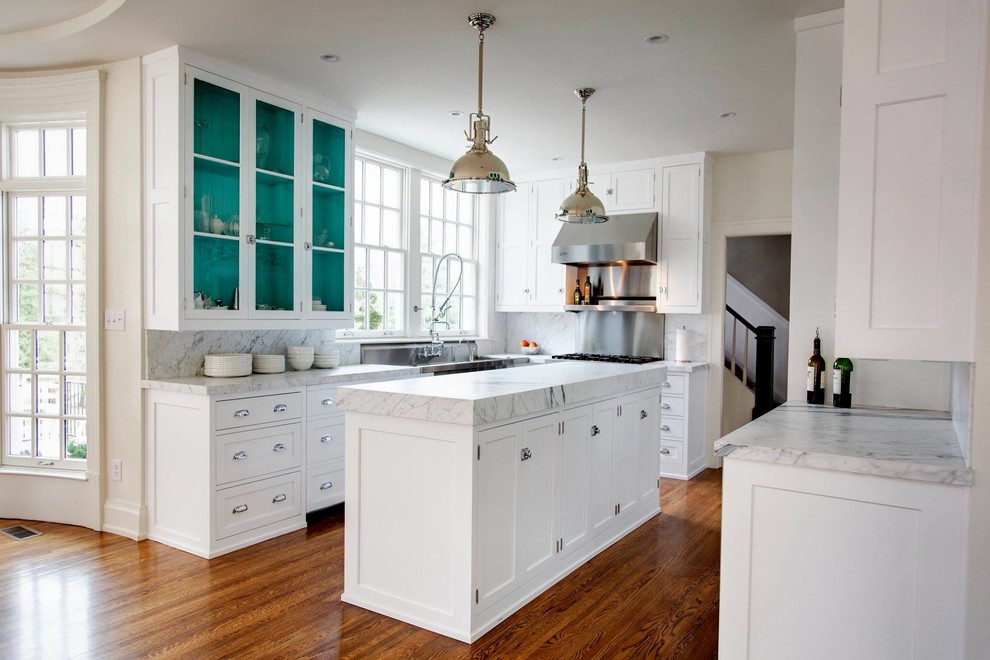 Klassische Küche in U-Form mit Glasfronten, weißen Schränken, Küchengeräten aus Edelstahl, braunem Holzboden und Kücheninsel in Louisville