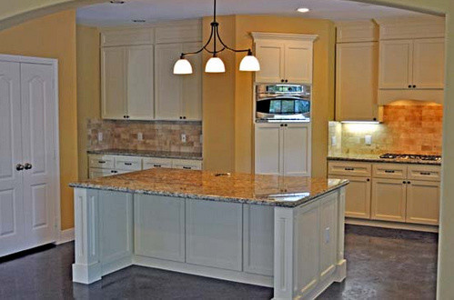Mid-sized elegant galley concrete floor eat-in kitchen photo in Houston with shaker cabinets, white cabinets, granite countertops, beige backsplash, ceramic backsplash, stainless steel appliances and an island