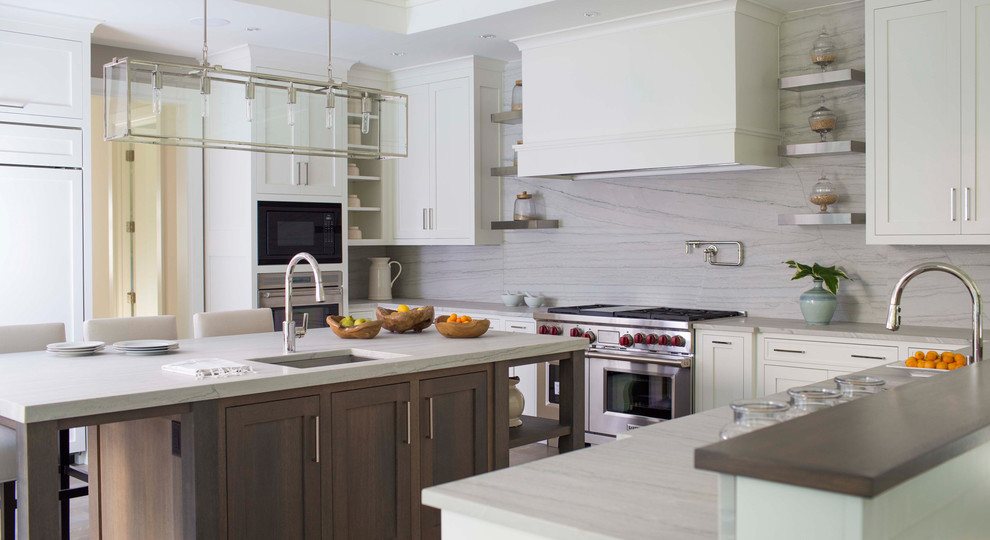 Inspiration for a mid-sized l-shaped light wood floor eat-in kitchen remodel in New York with a drop-in sink, white cabinets, marble countertops, white backsplash, stone tile backsplash, stainless steel appliances and an island