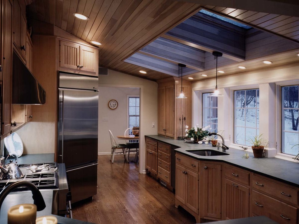 Inspiration for a large contemporary galley kitchen/diner in Cleveland with a built-in sink, recessed-panel cabinets, medium wood cabinets, stainless steel appliances, medium hardwood flooring and an island.