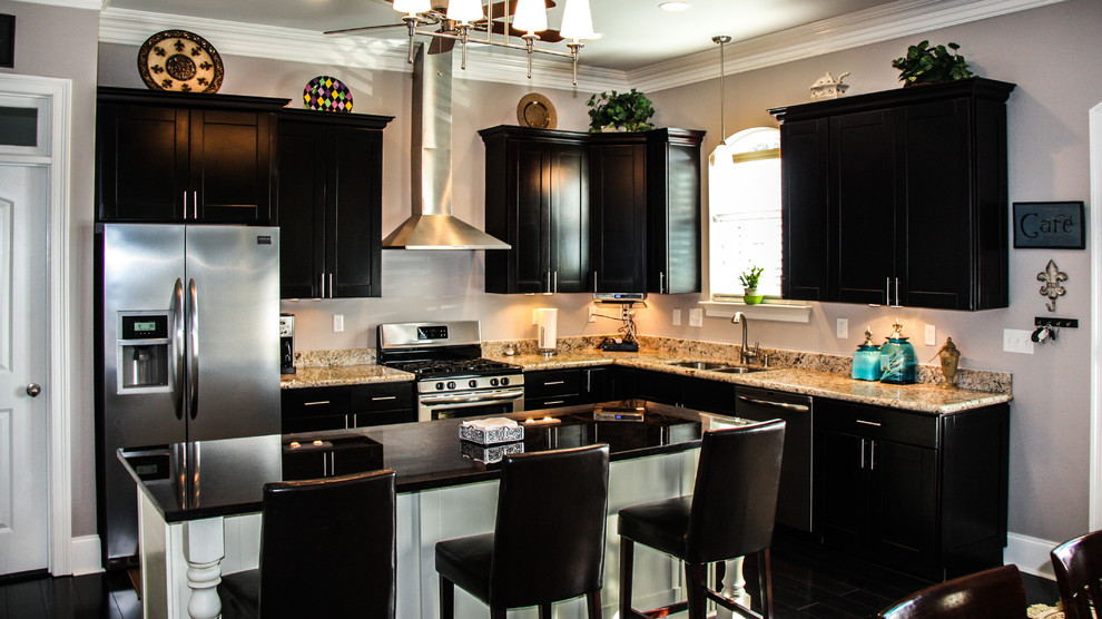 Kitchen - mid-sized modern dark wood floor and brown floor kitchen idea in New Orleans with beaded inset cabinets, beige backsplash, stainless steel appliances, an island and an undermount sink