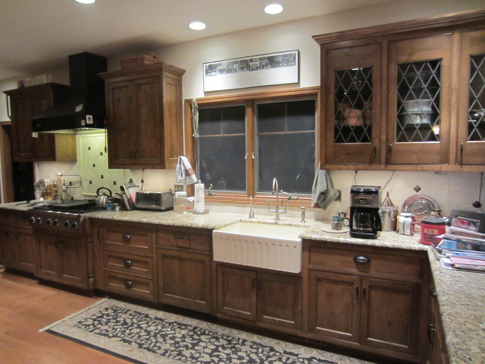 This is an example of a medium sized classic single-wall kitchen in Kansas City with medium wood cabinets, medium hardwood flooring and a breakfast bar.