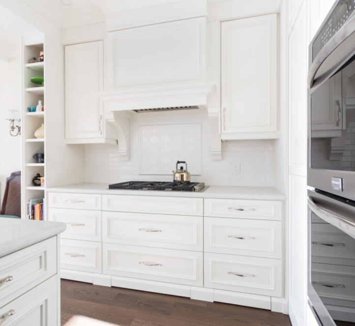 Exempel på ett mellanstort klassiskt kök, med en undermonterad diskho, luckor med infälld panel, vita skåp, marmorbänkskiva, vitt stänkskydd, stänkskydd i keramik, rostfria vitvaror, mörkt trägolv, en köksö och brunt golv