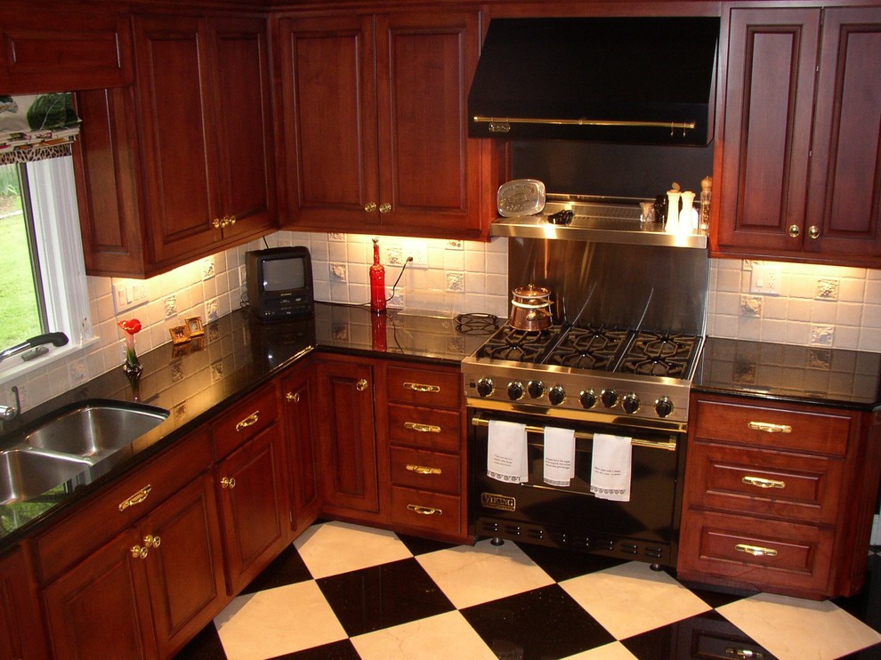 Bild på ett kök, med luckor med upphöjd panel, skåp i mörkt trä, granitbänkskiva, beige stänkskydd, stänkskydd i stenkakel, rostfria vitvaror och klinkergolv i keramik