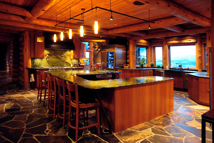シアトルにある高級な広いトラディショナルスタイルのおしゃれなキッチン (フラットパネル扉のキャビネット、中間色木目調キャビネット、エプロンフロントシンク、御影石カウンター、グレーのキッチンパネル、石スラブのキッチンパネル、シルバーの調理設備、スレートの床、茶色い床) の写真