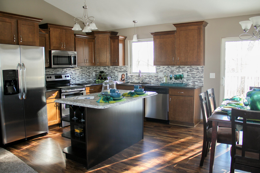 Example of a large classic l-shaped medium tone wood floor and brown floor eat-in kitchen design in Other with a double-bowl sink, recessed-panel cabinets, medium tone wood cabinets, laminate countertops, multicolored backsplash, ceramic backsplash, stainless steel appliances and an island