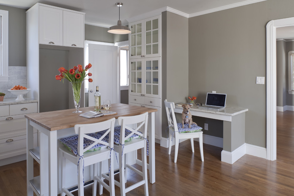 Inspiration for a timeless enclosed kitchen remodel in Los Angeles with glass-front cabinets, wood countertops and white cabinets