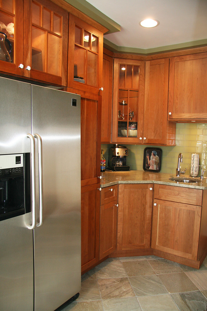 Bild på ett avskilt, litet vintage l-kök, med en undermonterad diskho, skåp i shakerstil, skåp i mörkt trä, granitbänkskiva, grönt stänkskydd, stänkskydd i glaskakel, rostfria vitvaror, skiffergolv och grönt golv