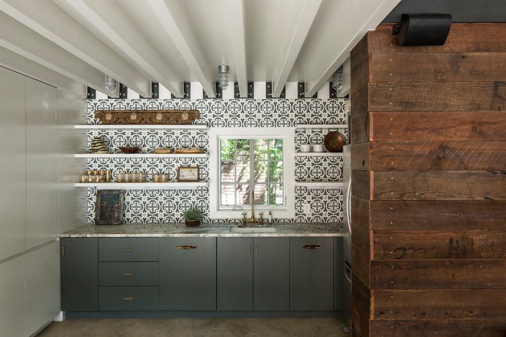 Inspiration för ett industriellt beige linjärt beige kök, med en undermonterad diskho, släta luckor, blå skåp, blått stänkskydd, stänkskydd i mosaik, betonggolv och grått golv
