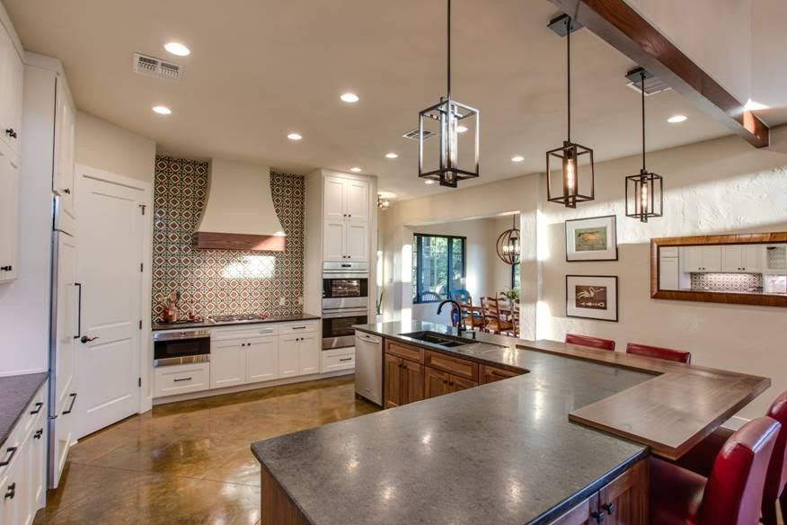 Bild på ett mellanstort lantligt kök, med en undermonterad diskho, skåp i shakerstil, skåp i mellenmörkt trä, träbänkskiva, flerfärgad stänkskydd, stänkskydd i keramik, rostfria vitvaror, betonggolv, flera köksöar och brunt golv