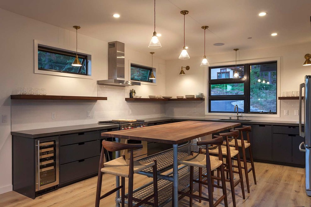 Mittelgroße Moderne Wohnküche in U-Form mit integriertem Waschbecken, grauen Schränken, Betonarbeitsplatte, Küchenrückwand in Weiß, Küchengeräten aus Edelstahl und hellem Holzboden in Sacramento