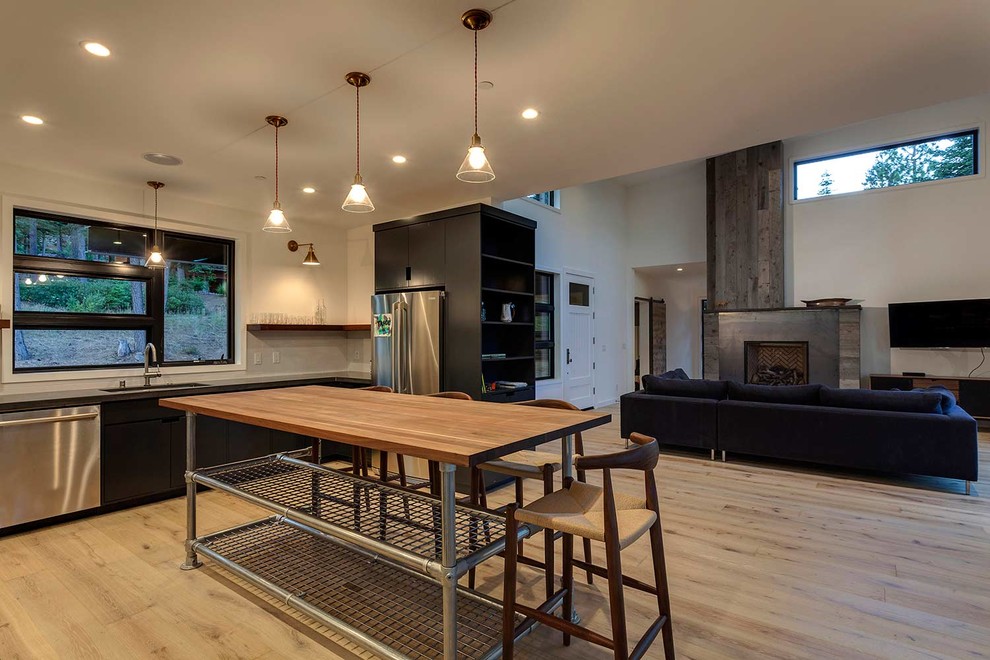 Пример оригинального дизайна: кухня-гостиная среднего размера в стиле модернизм с столешницей из бетона, белым фартуком, техникой из нержавеющей стали и светлым паркетным полом