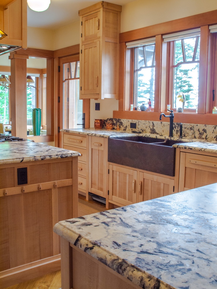 This is an example of a large rustic u-shaped kitchen/diner in Portland Maine with a belfast sink, laminate countertops, beige splashback, stone slab splashback and an island.