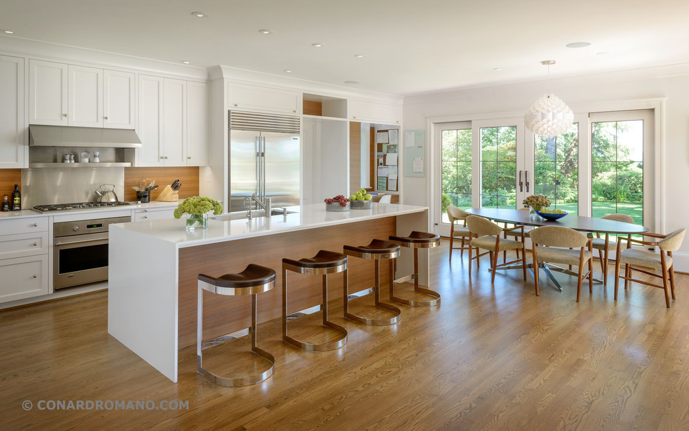Diseño de cocina contemporánea, grande, con fregadero de un seno, armarios con paneles empotrados, puertas de armario de madera oscura, encimera de cuarzo compacto, electrodomésticos con paneles, suelo de madera en tonos medios, una isla y salpicadero de madera