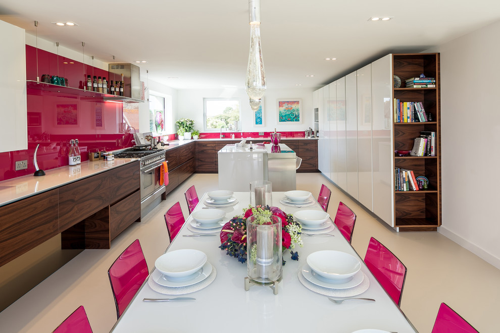 Design ideas for an expansive modern u-shaped kitchen in London with a submerged sink, flat-panel cabinets, composite countertops, pink splashback, glass sheet splashback, stainless steel appliances and an island.