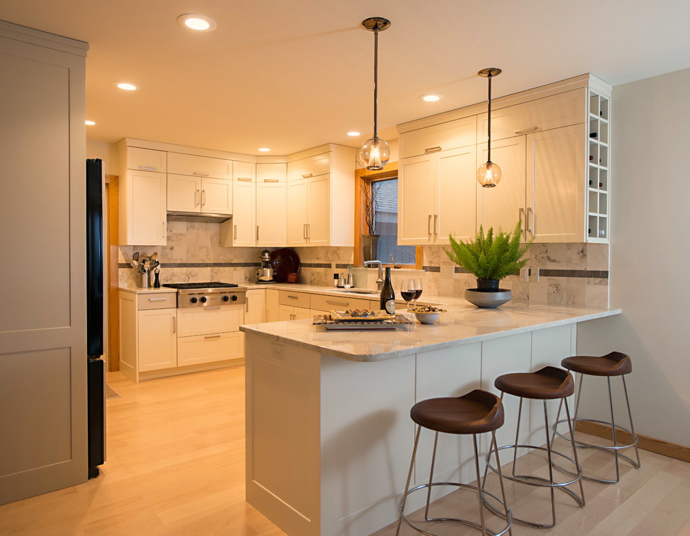 Klassische Küche mit Unterbauwaschbecken, Schrankfronten im Shaker-Stil, weißen Schränken, braunem Holzboden und Halbinsel in New York