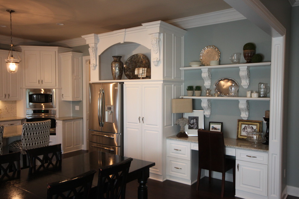 Foto de cocina clásica abierta con armarios con paneles con relieve, puertas de armario blancas, encimera de granito, electrodomésticos de acero inoxidable y una isla
